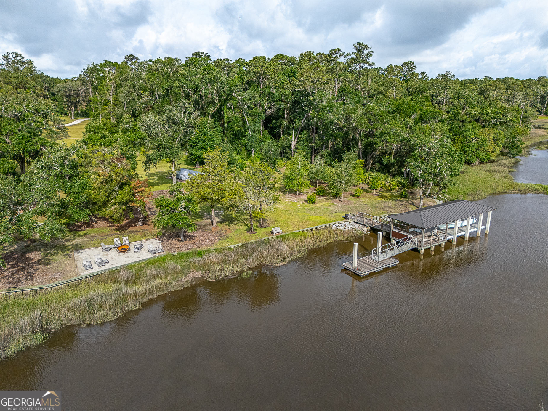 24 Carriage Drive St. Simons Island, GA 31522 - Photo 28 of 67 a view of a lake with lawn chairs