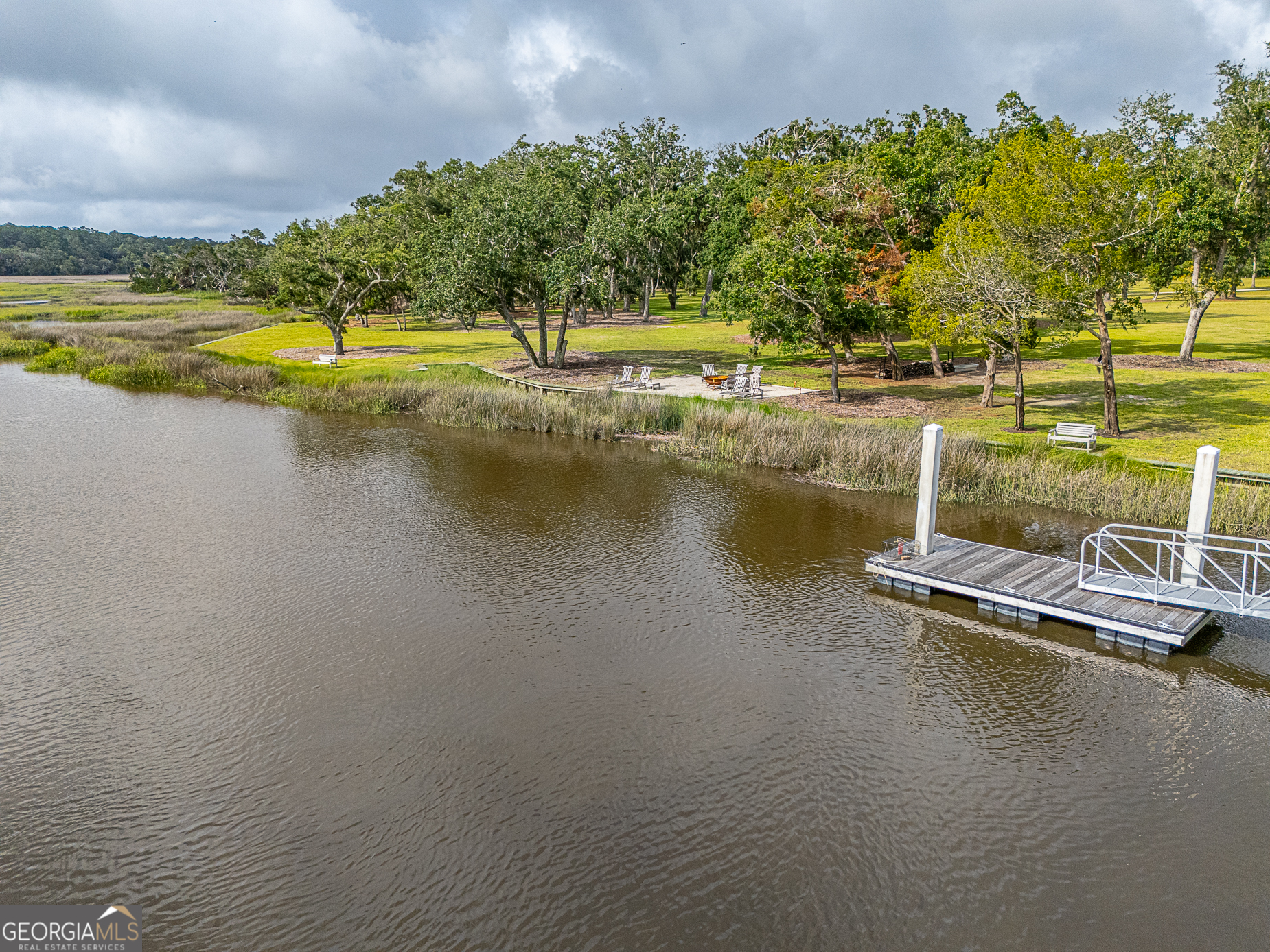 24 Carriage Drive St. Simons Island, GA 31522 - Photo 32 of 67 a view of a lake with lawn chairs