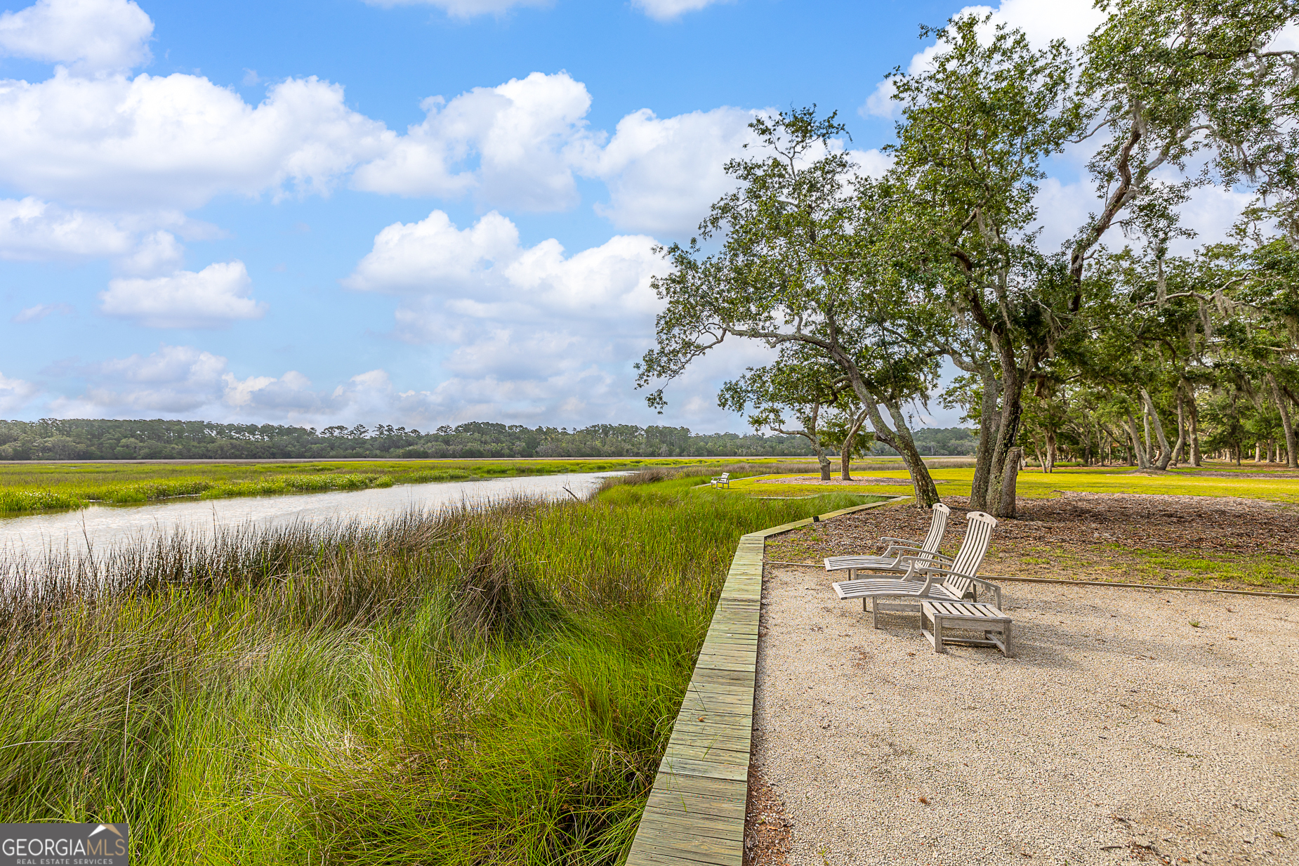 24 Carriage Drive St. Simons Island, GA 31522 - Photo 51 of 67 a view of an swimming pool and trees in the background