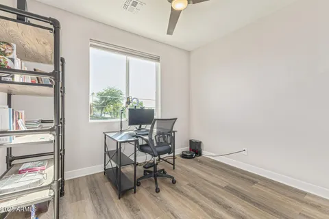 a view of a workspace with furniture and wooden floor