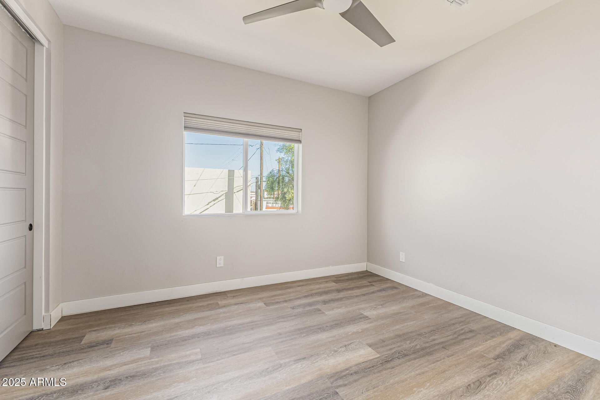 2315 East Pinchot Avenue, Unit 113 Phoenix, AZ 85016 - Photo 35 of 54 an empty room with wooden floor and windows