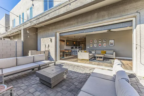 a roof deck with table and chairs and potted plants