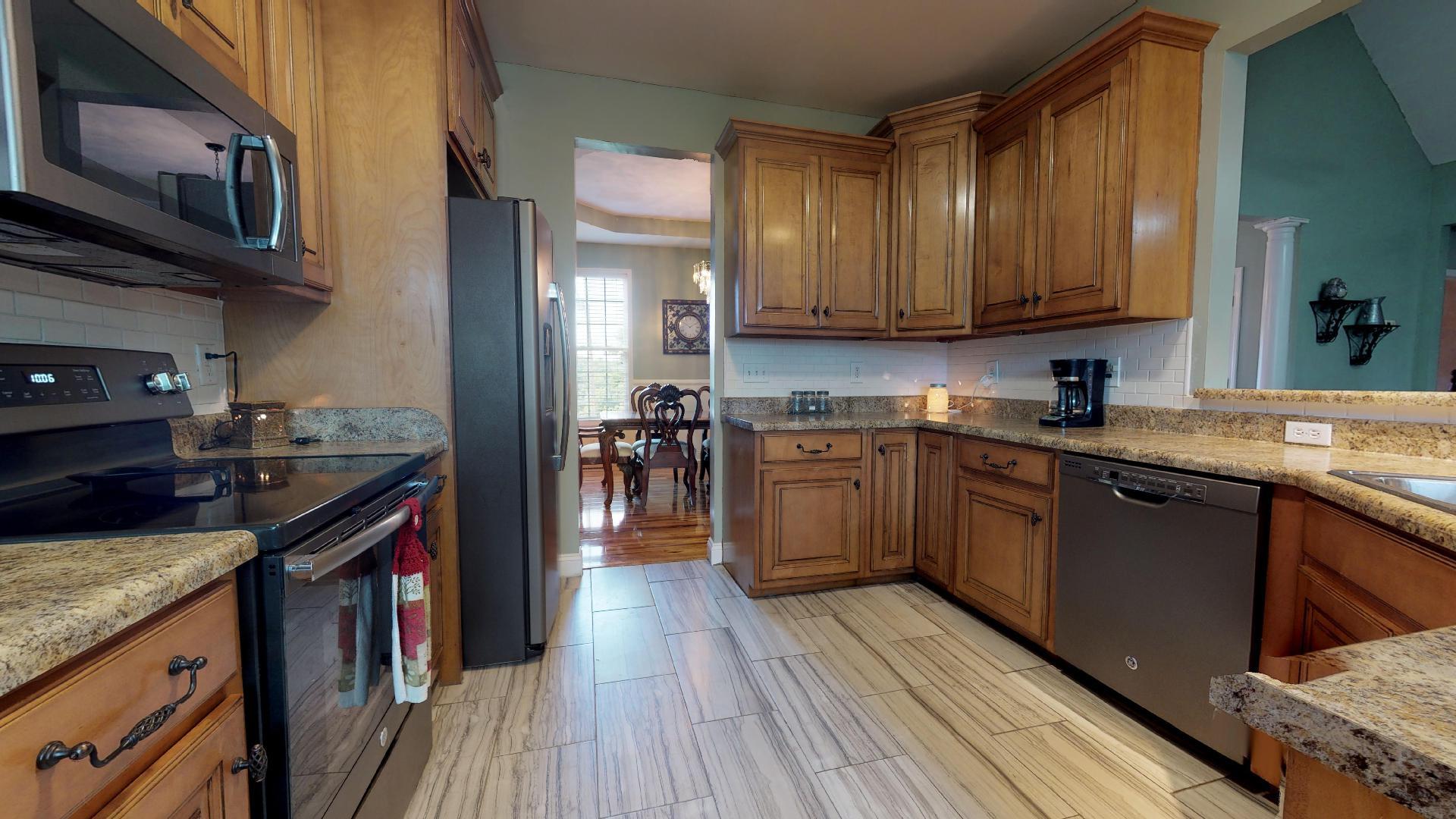 1489 Newman Road Prospect, TN 38477 - Photo 5 of 23 a kitchen with stainless steel appliances granite countertop wooden cabinets a stove top oven a sink and dishwasher