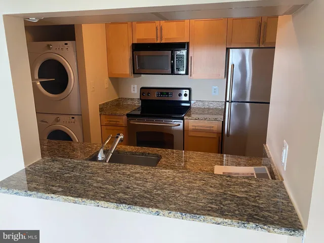 a view of a kitchen with a sink washer and dryer