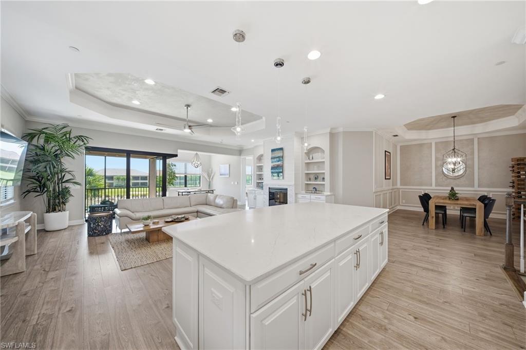 9658 Montelanico Loop, Unit 201 Naples, FL 34119 - Photo 1 of 46 a large white kitchen with wooden floor and a dining table