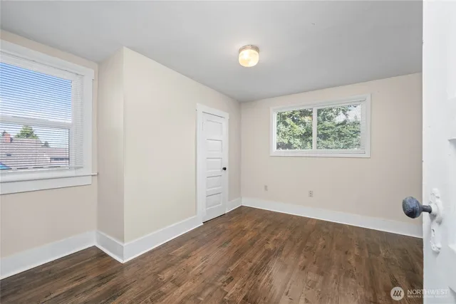 an empty room with a window and wooden floor