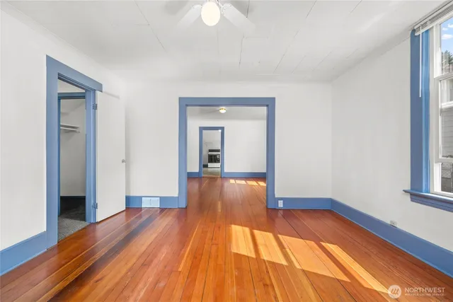 a view of a room with wooden floor and a window
