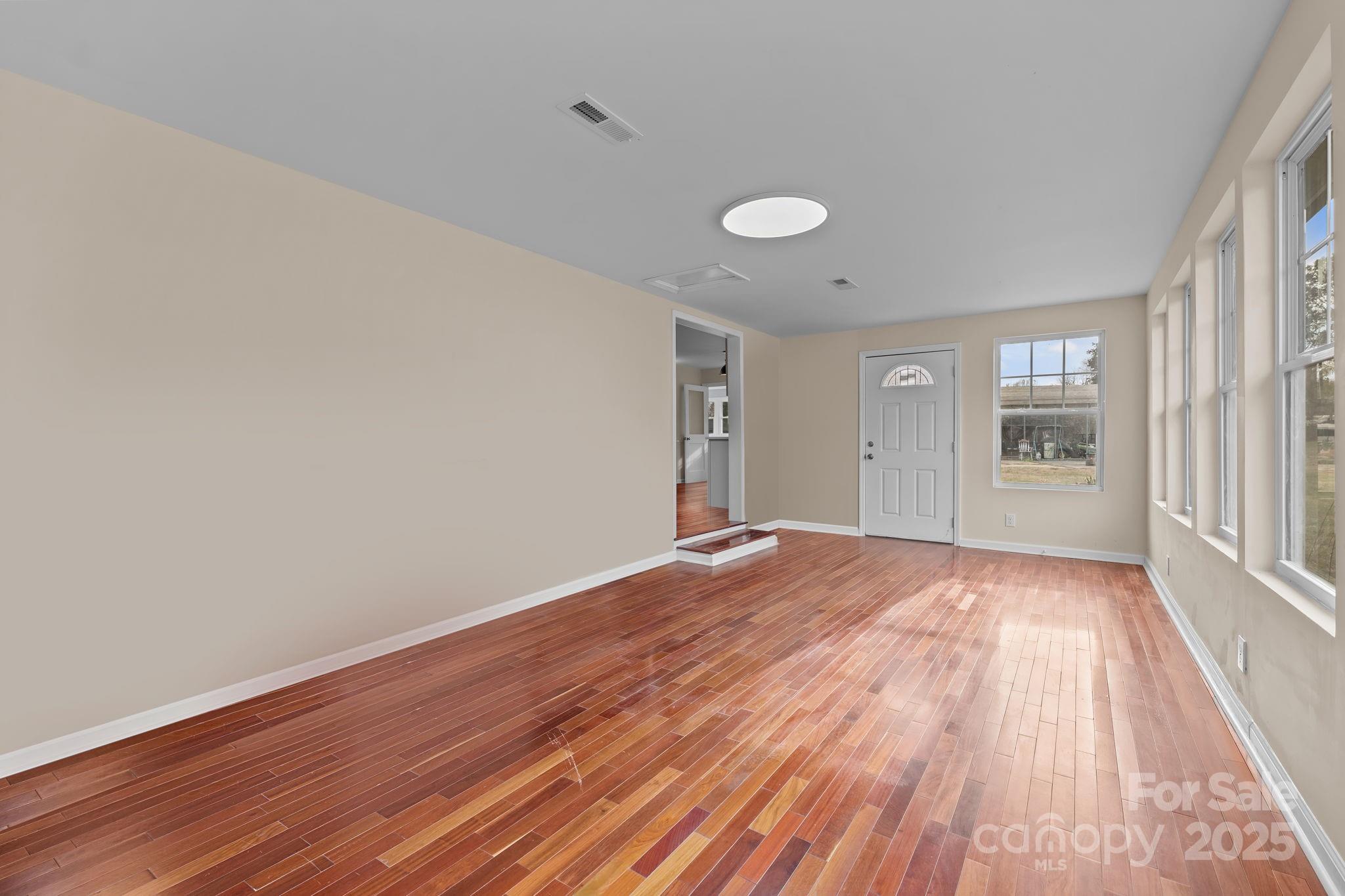 2337 Belmont Road Linwood, NC 27299 - Photo 13 of 46 a view of an empty room with wooden floor and a window