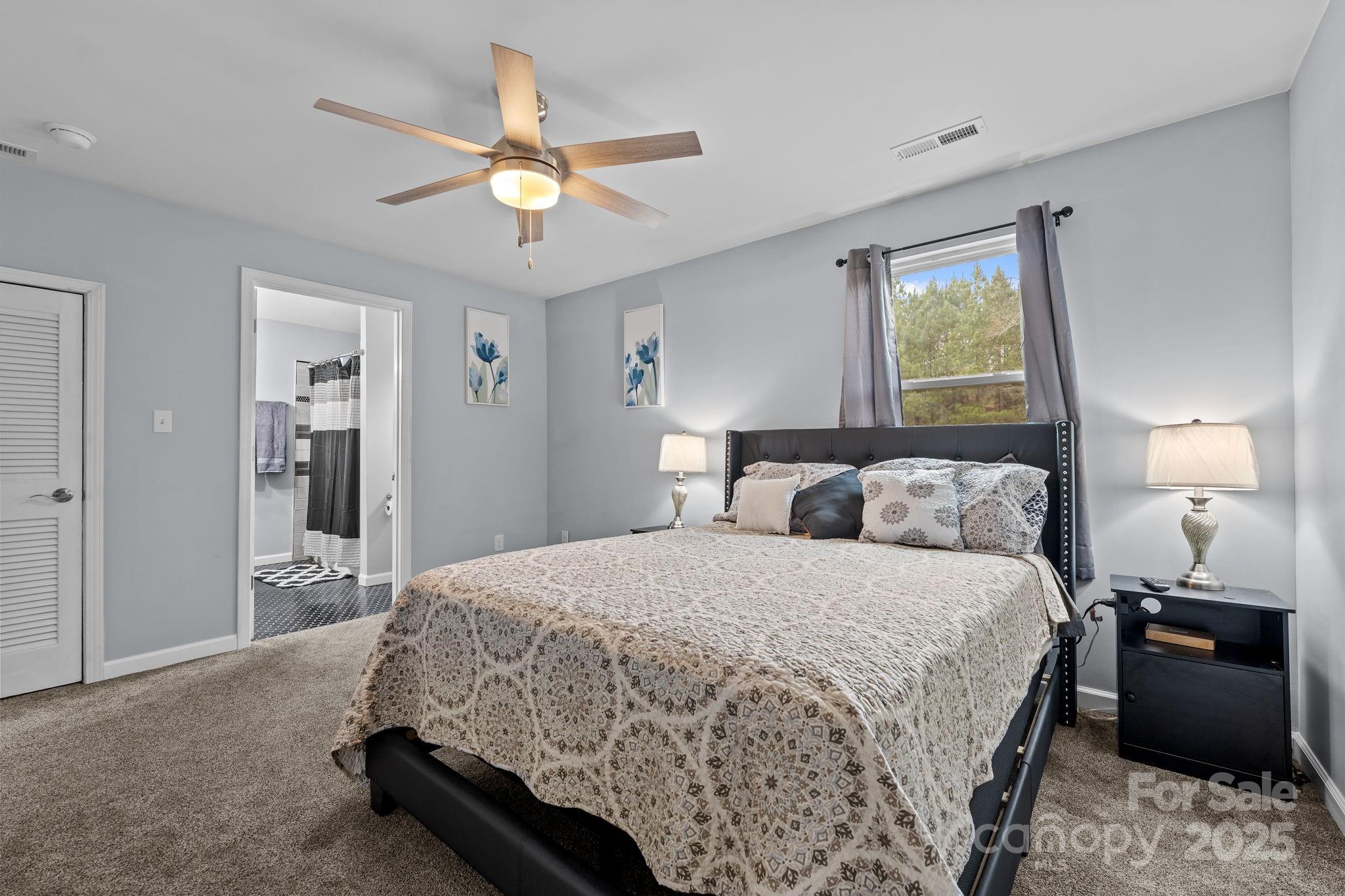 2337 Belmont Road Linwood, NC 27299 - Photo 24 of 46 a bedroom with a bed and a chandelier
