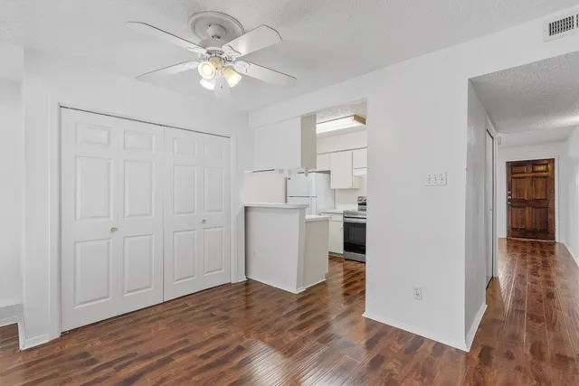 a view of a kitchen with wooden floor and a ceiling fan