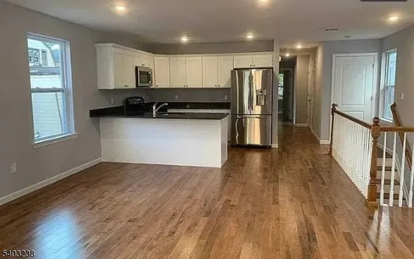 a kitchen with stainless steel appliances wooden floors and wooden cabinets