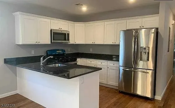 a kitchen with granite countertop a refrigerator sink and microwave