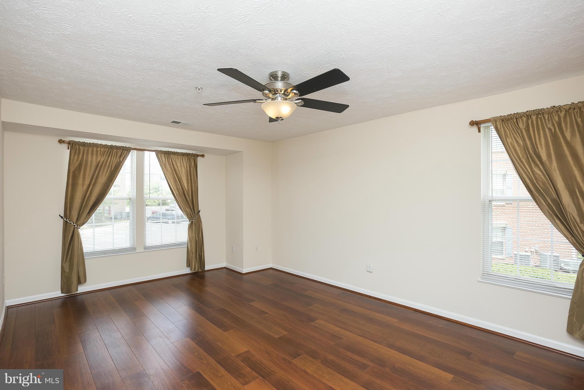 693 Winding Stream Way, Unit 201 Odenton, MD 21113 - Photo 11 of 28 a view of empty room with wooden floor and fan