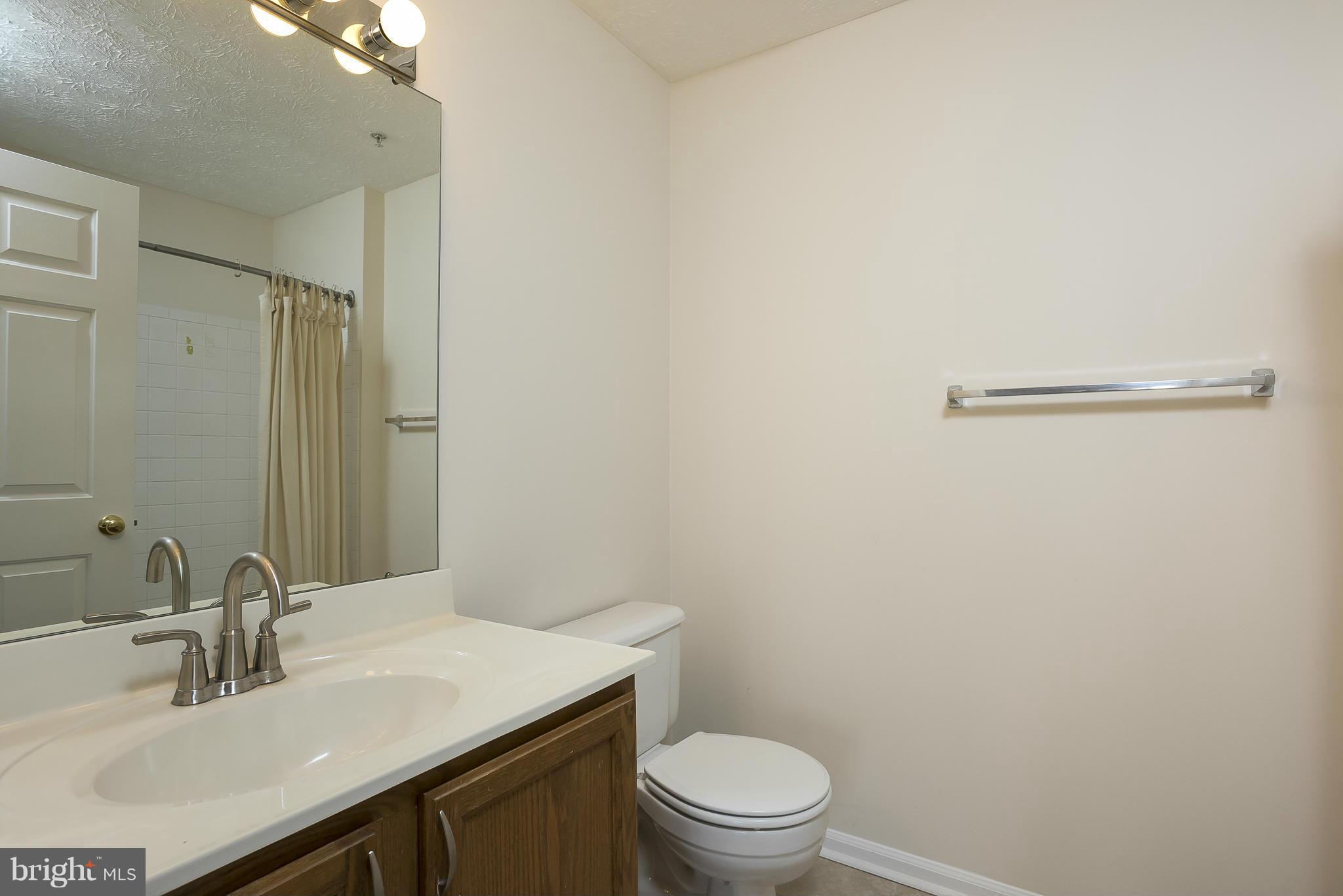 693 Winding Stream Way, Unit 201 Odenton, MD 21113 - Photo 13 of 28 a bathroom with a sink vanity mirror and toilet