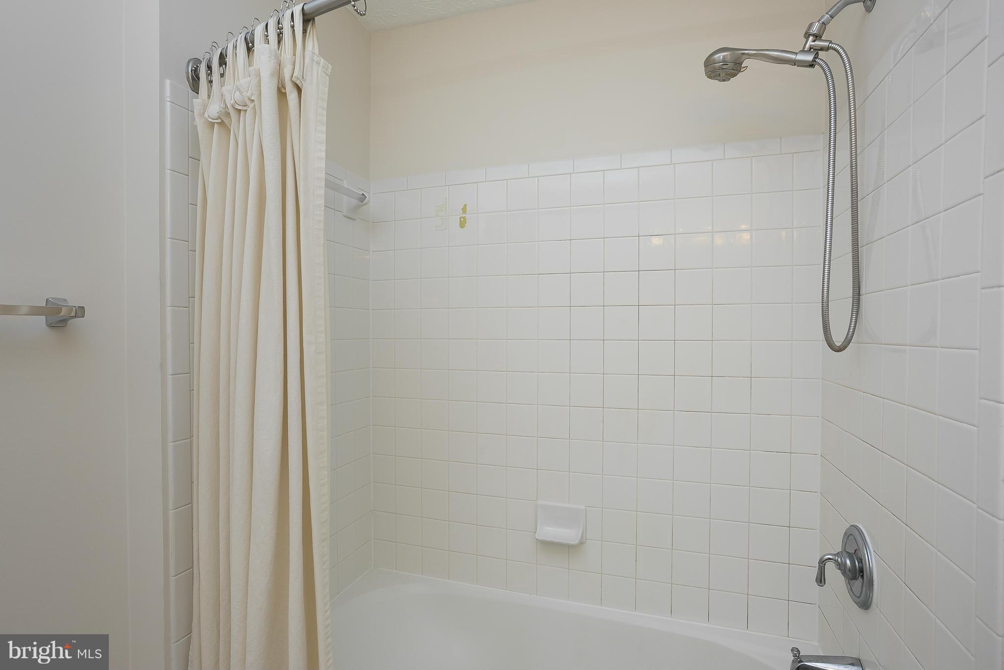 693 Winding Stream Way, Unit 201 Odenton, MD 21113 - Photo 14 of 28 a bathroom with a shower and a bath tub