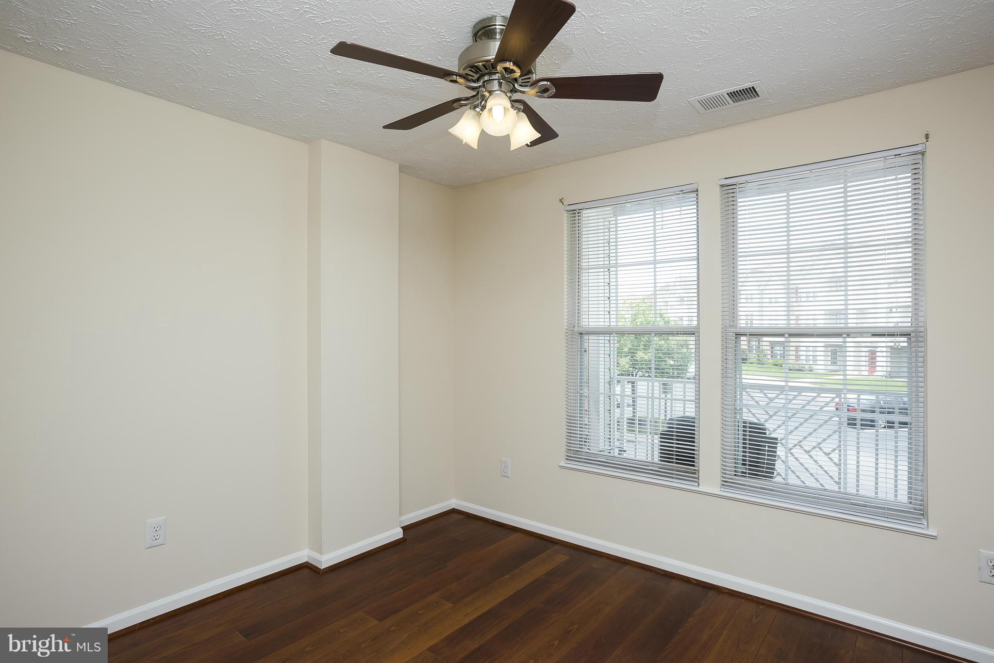 693 Winding Stream Way, Unit 201 Odenton, MD 21113 - Photo 16 of 28 a view of an empty room with wooden floor and a window