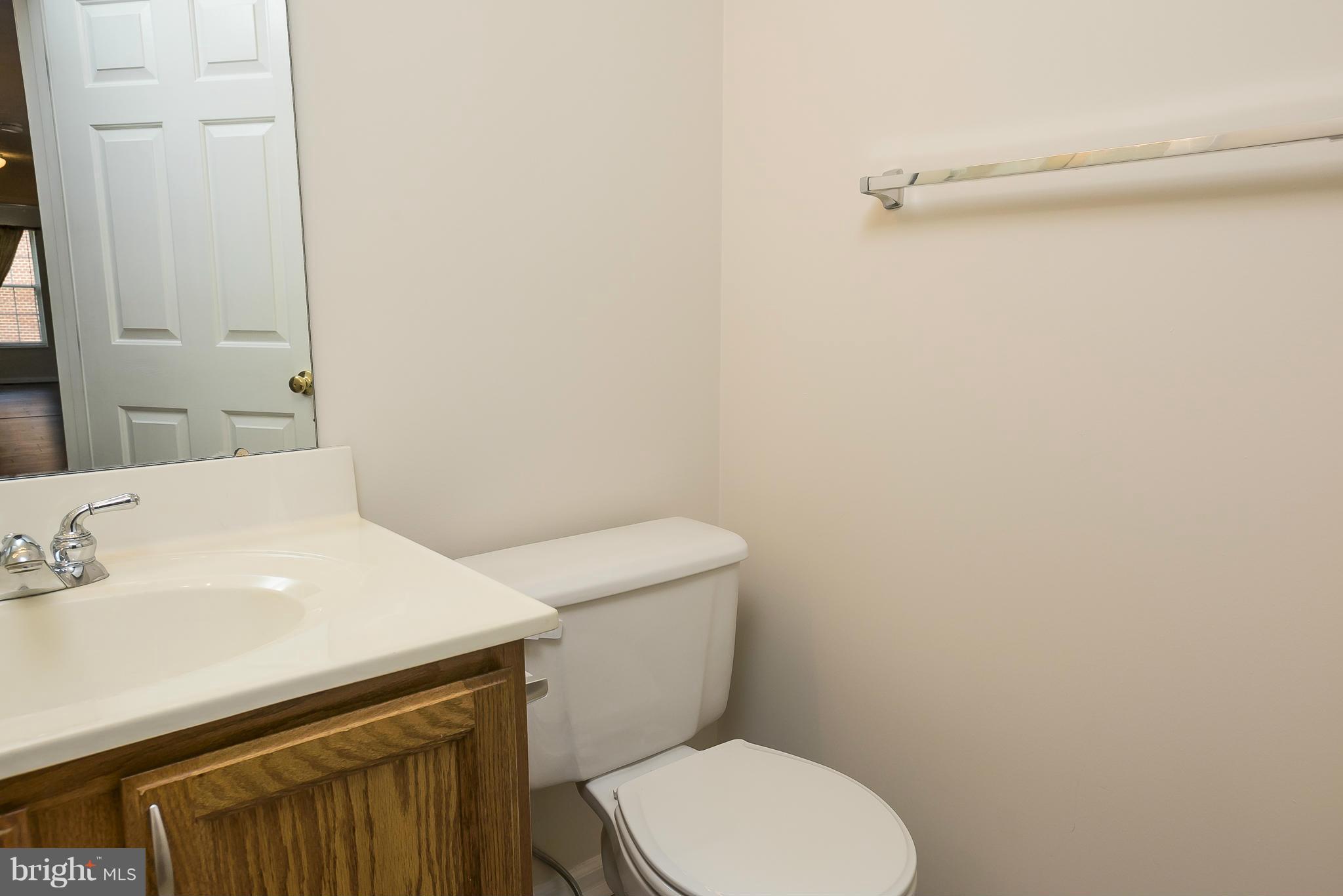 693 Winding Stream Way, Unit 201 Odenton, MD 21113 - Photo 17 of 28 a bathroom with a sink a toilet and a mirror