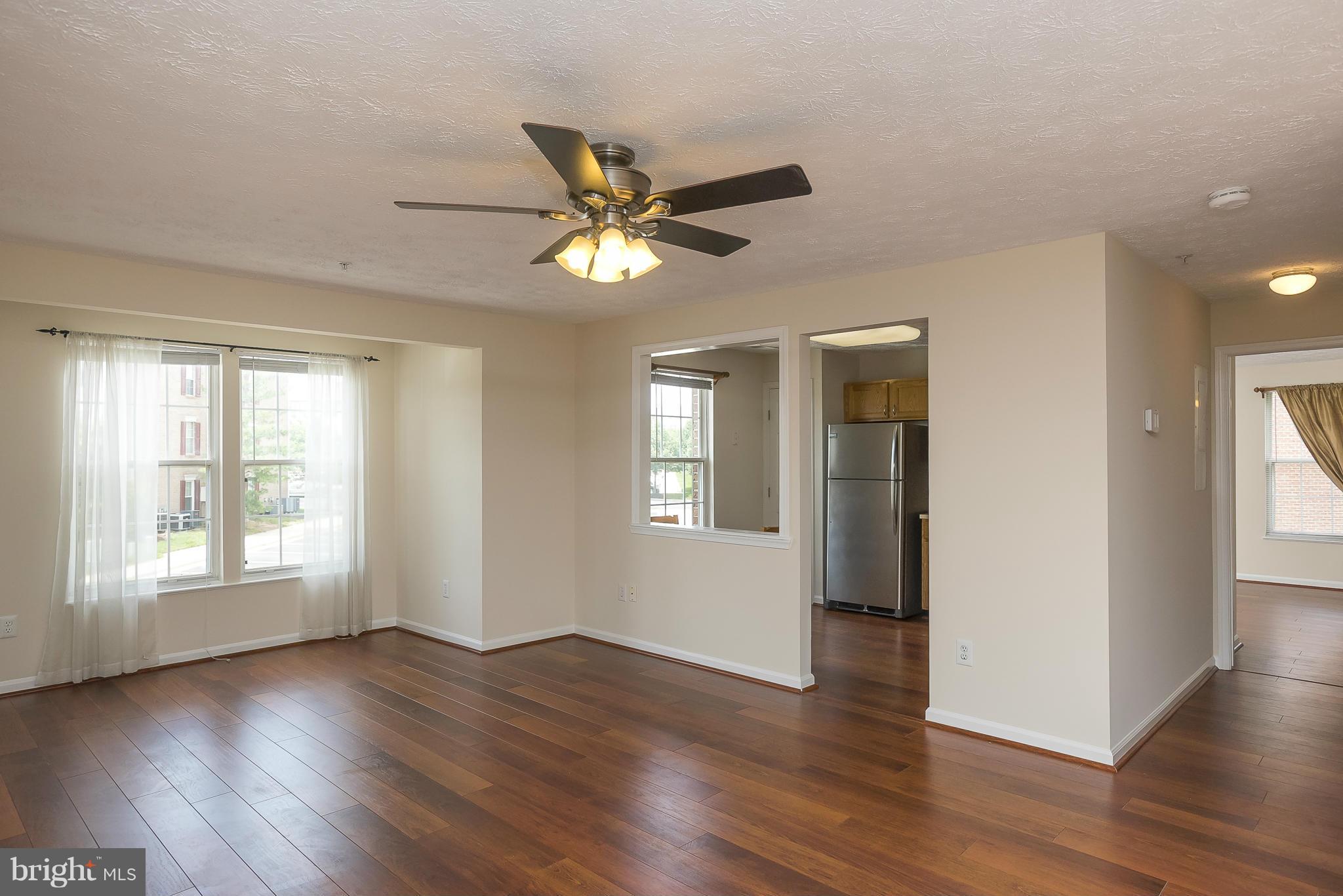 693 Winding Stream Way, Unit 201 Odenton, MD 21113 - Photo 3 of 28 a view of an empty room with window and wooden floor