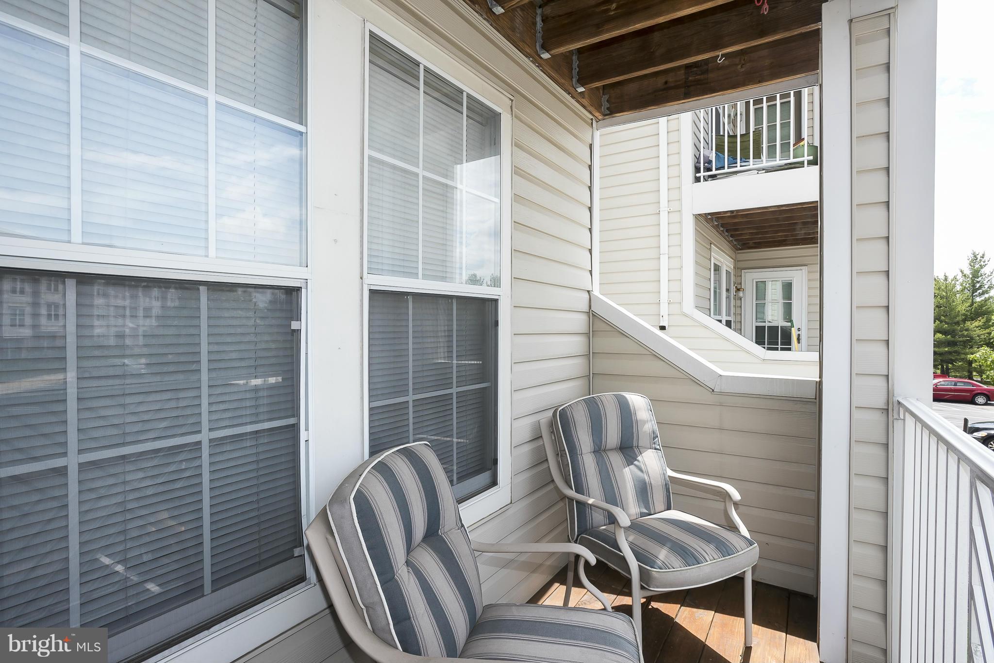 693 Winding Stream Way, Unit 201 Odenton, MD 21113 - Photo 21 of 28 a view of chair and table in the balcony