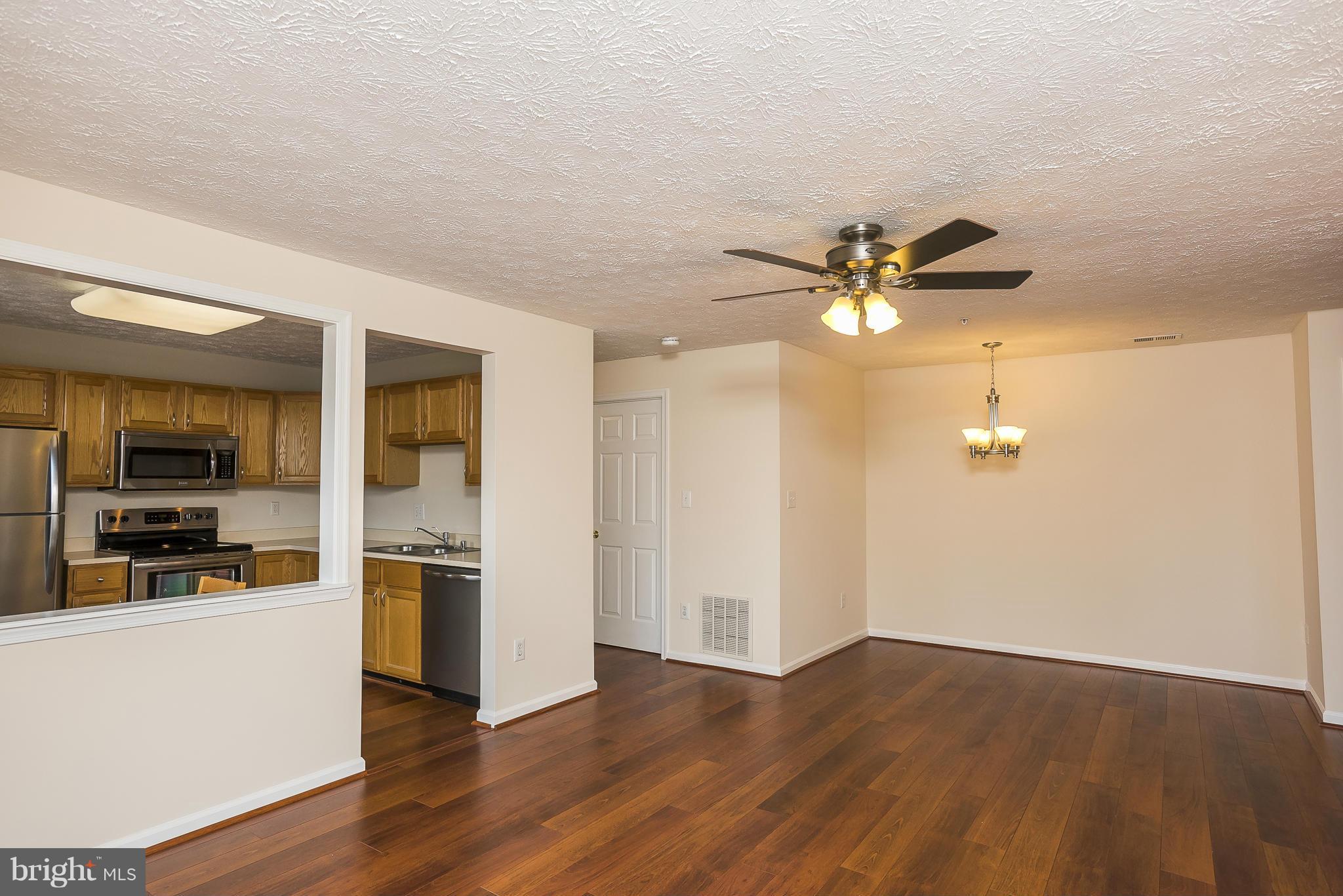 693 Winding Stream Way, Unit 201 Odenton, MD 21113 - Photo 4 of 28 a view of a kitchen with a sink a ceiling fan and stainless steel appliances
