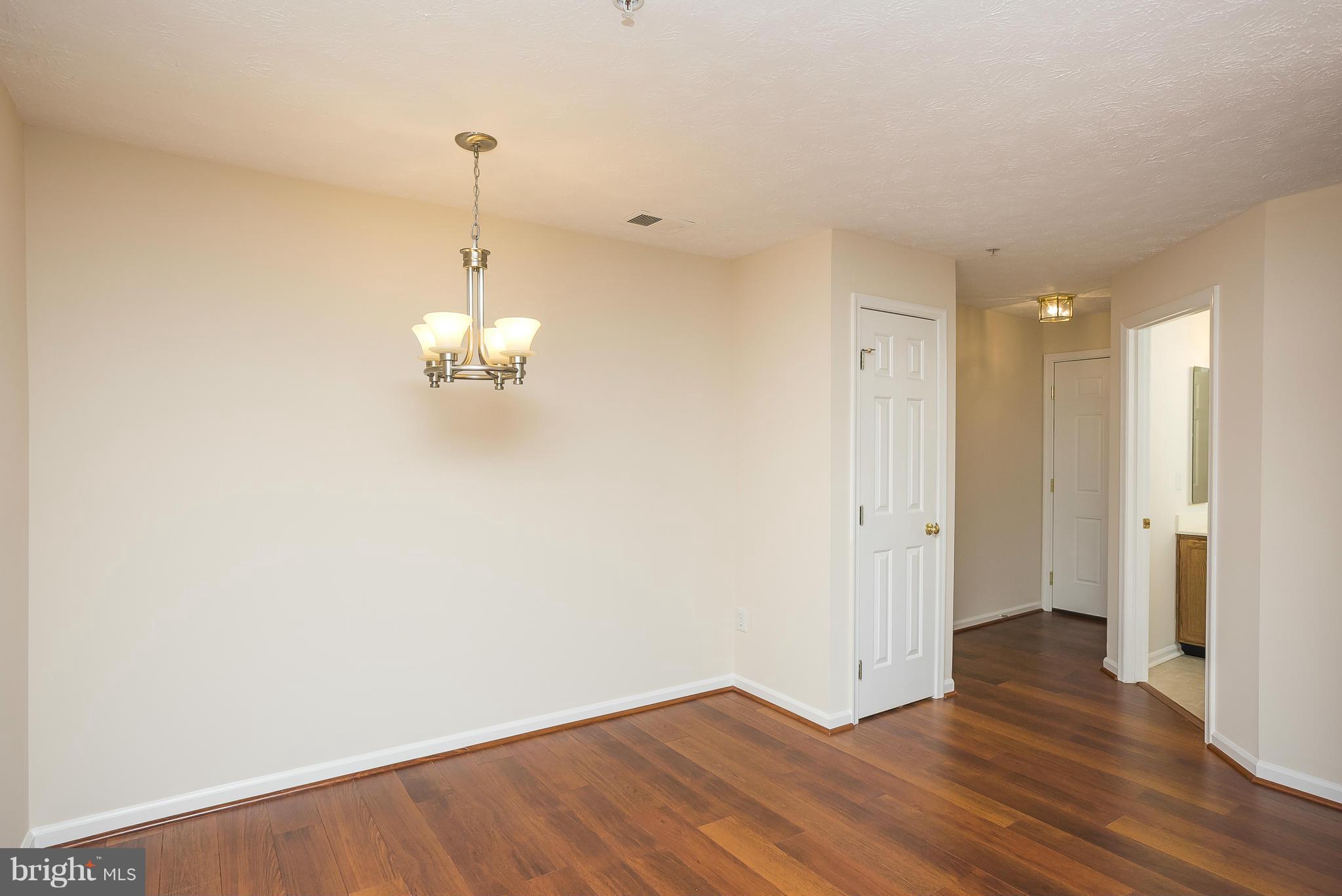 693 Winding Stream Way, Unit 201 Odenton, MD 21113 - Photo 5 of 28 a view of an empty room with wooden floor and windows