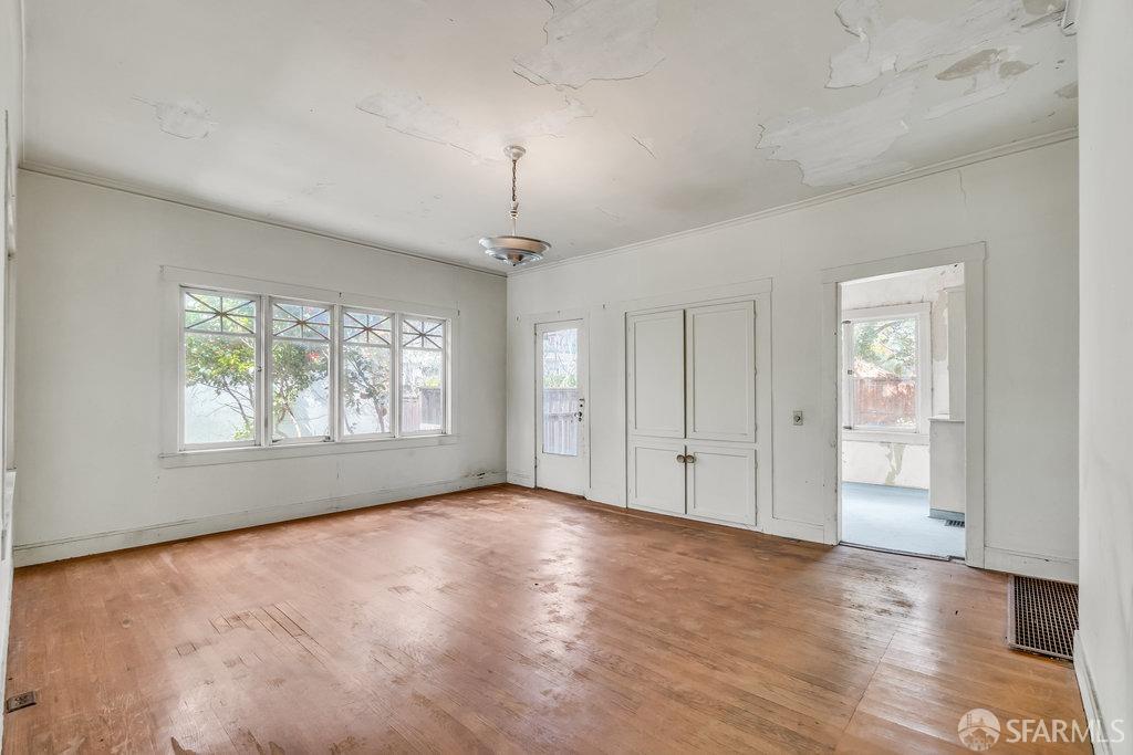 2815 Ashby Avenue Berkeley, CA 94705 - Photo 19 of 57 an empty room with wooden floor chandelier and windows
