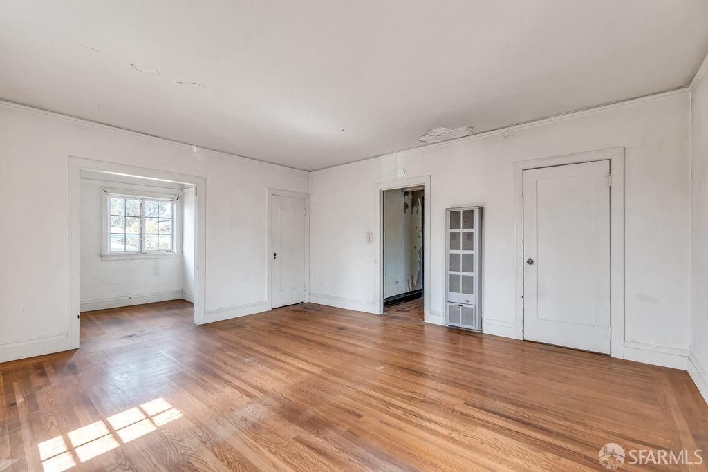 2815 Ashby Avenue Berkeley, CA 94705 - Photo 27 of 57 a view of an empty room with window and wooden floor