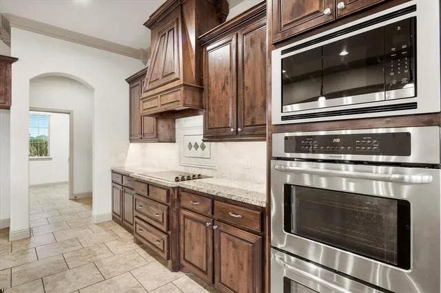 a kitchen with granite countertop a stove and a microwave