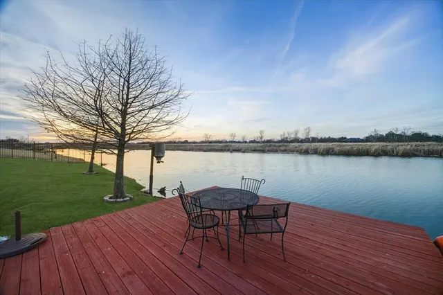 a lake view with a table and chairs on wooden floor and lake view