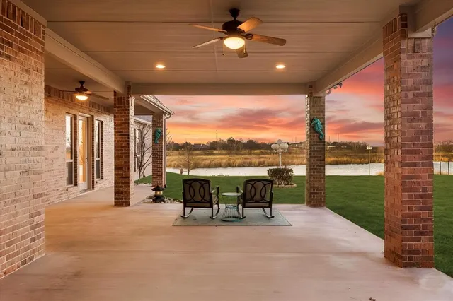 a view of a patio with couches and table and chairs next to yard and a building