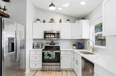 a kitchen with stainless steel appliances a refrigerator sink and cabinets
