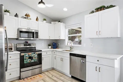 a kitchen with cabinets stainless steel appliances and a sink
