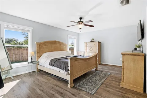 a bedroom with a bed wooden floor and window