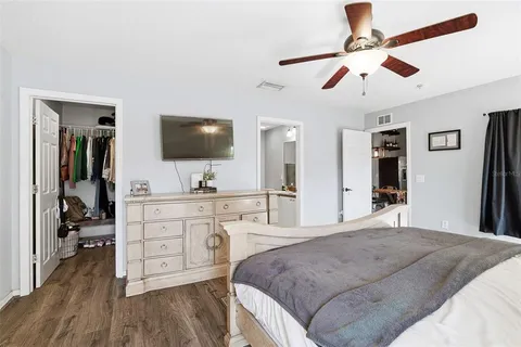 a bedroom with a large bed and a flat tv screen