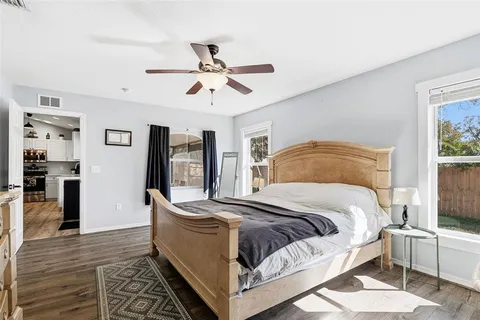 a bedroom with a large bed a flat tv screen and dresser