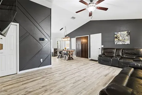 a kitchen with stainless steel appliances kitchen island granite countertop a refrigerator a stove and a sink with wooden floor