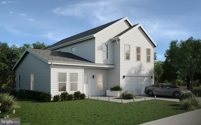 a front view of a house with a yard and green space