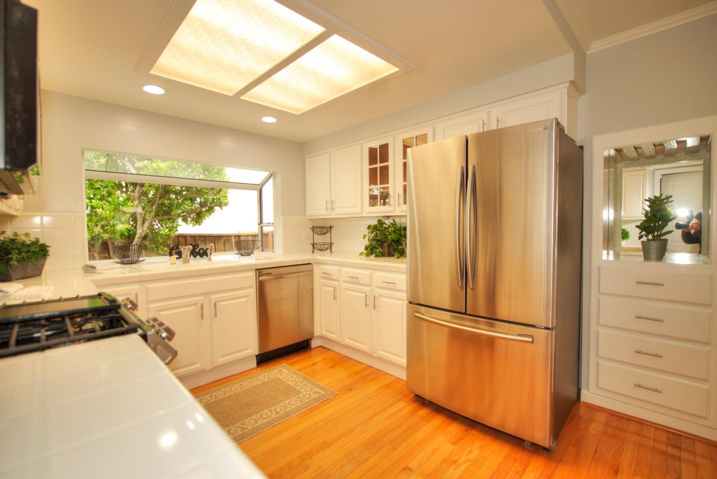 1396 Fallen Leaf Drive Milpitas, CA 95035 - Photo 11 of 43 a kitchen with a refrigerator and white cabinets