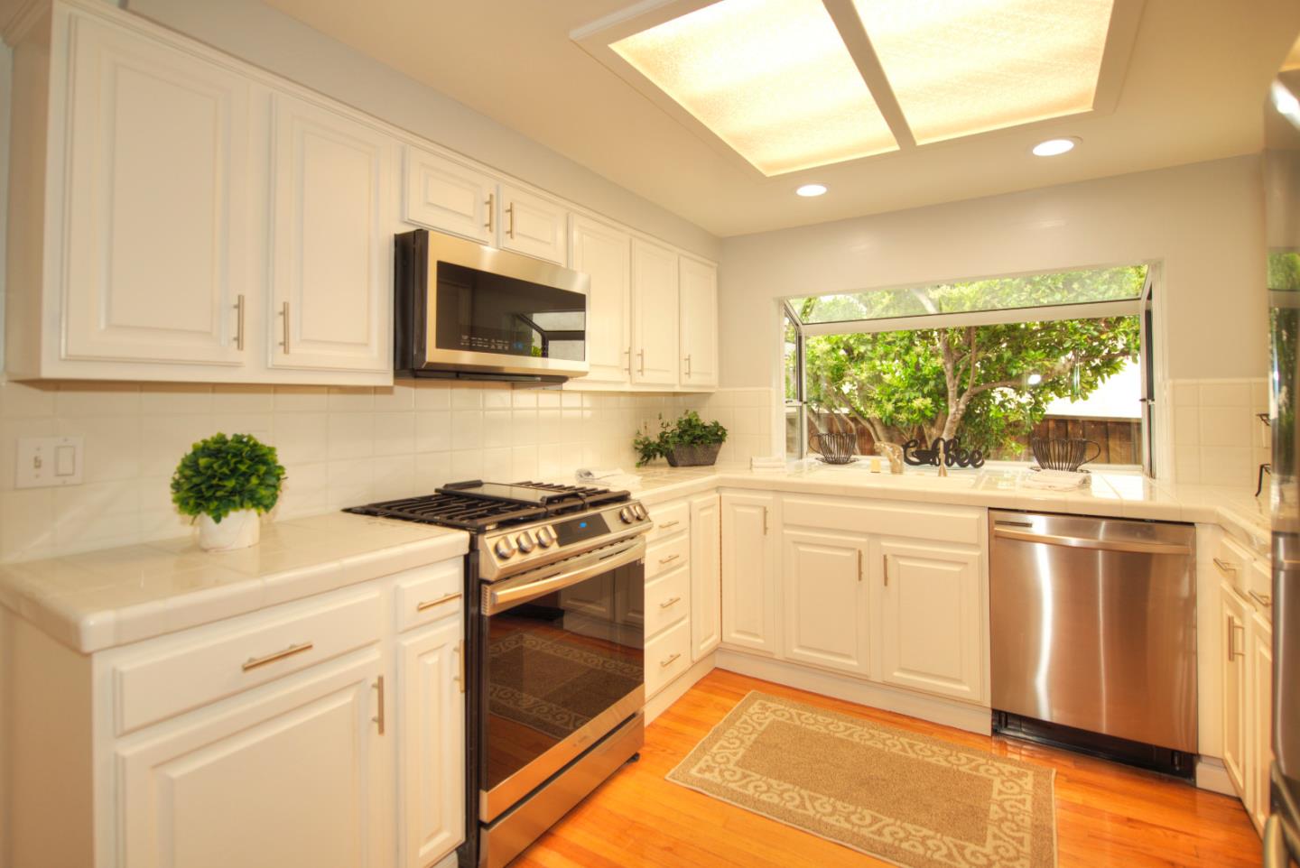 1396 Fallen Leaf Drive Milpitas, CA 95035 - Photo 10 of 43 a kitchen with stainless steel appliances granite countertop a stove a sink and a microwave