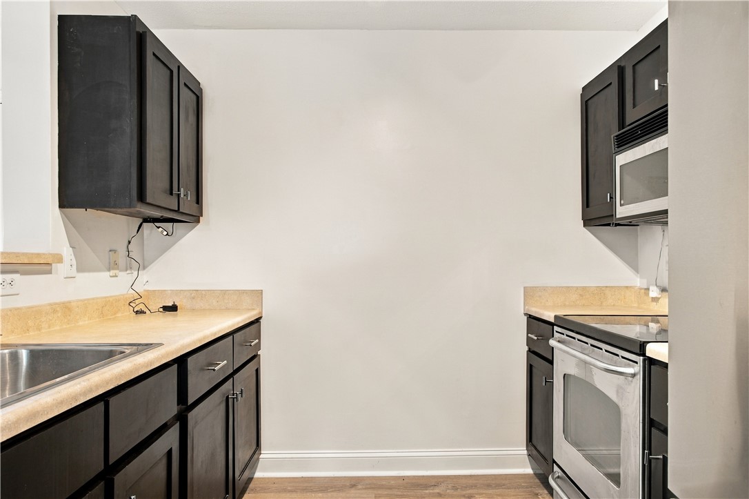 636 Lookover Drive Anderson, SC 29621 - Photo 10 of 34 Contrasting dark cabinetry paired with durable countertops highlights this functional galley kitchen layout.
