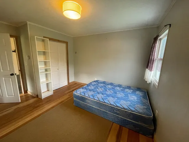 a bed sitting in a bedroom next to a window
