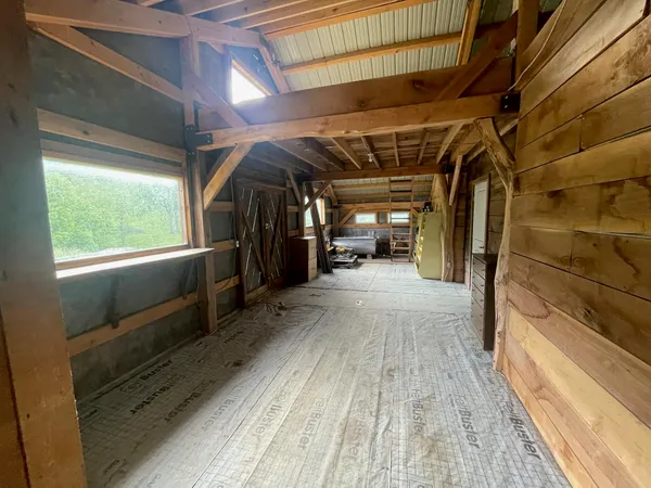 a view of a room with wooden floor and a window