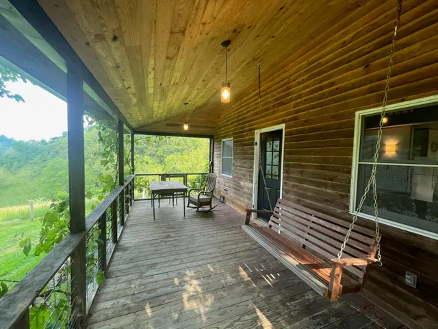 a view of a patio with table and chairs with wooden floor and fence