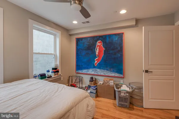 a bedroom with a bed and a painting on the wall