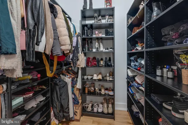 a view of walk in closet with clothes and shoes