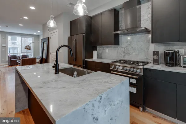 a kitchen with stainless steel appliances granite countertop a sink a stove and a refrigerator