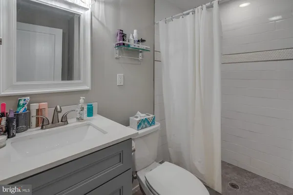 a bathroom with a sink a toilet and shower curtain