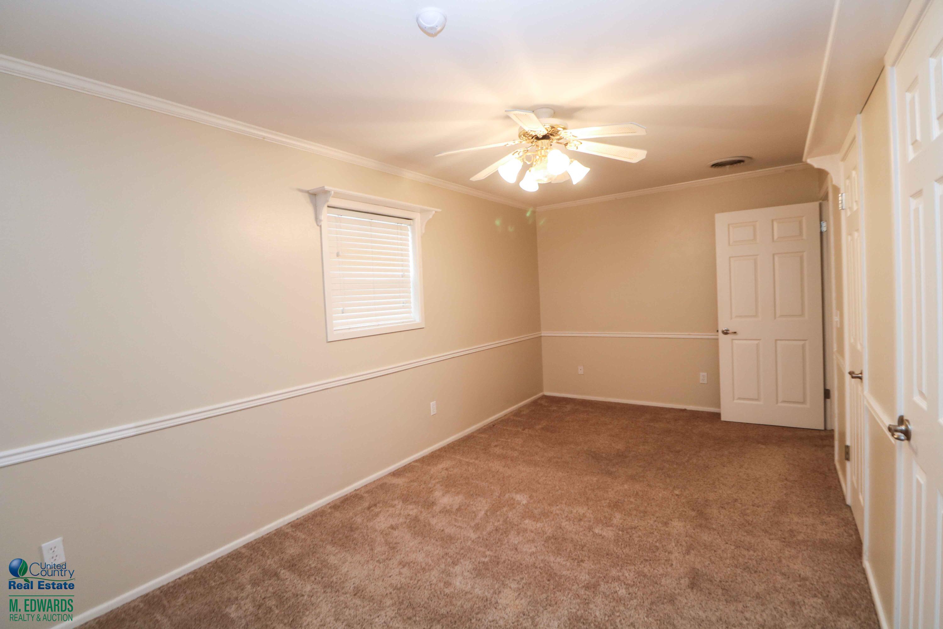 200 Crescent Drive Littlefield, TX 79339 - Photo 12 of 25 an empty room with a window and ceiling fan