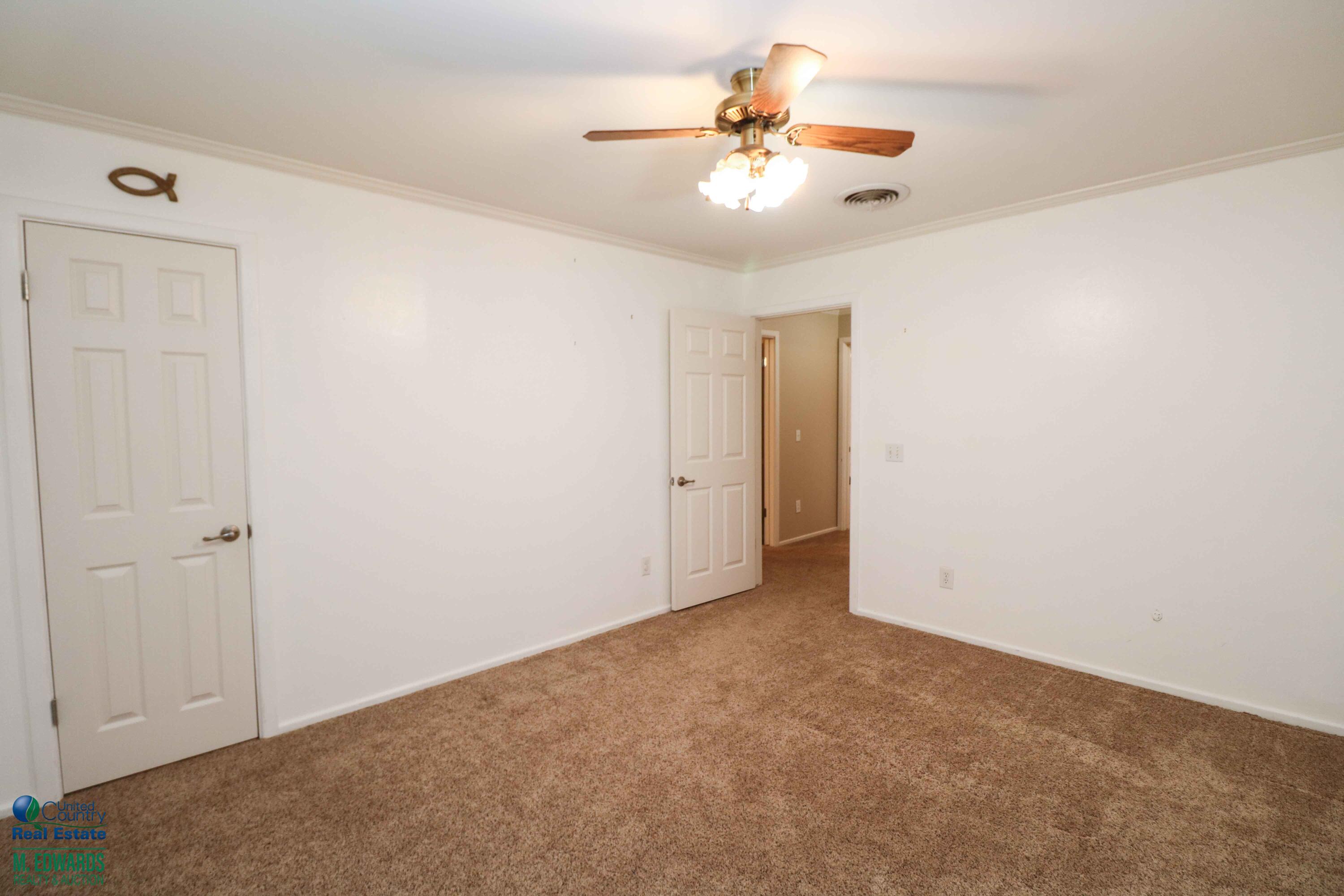 200 Crescent Drive Littlefield, TX 79339 - Photo 15 of 25 an empty room with a chandelier fan and closet