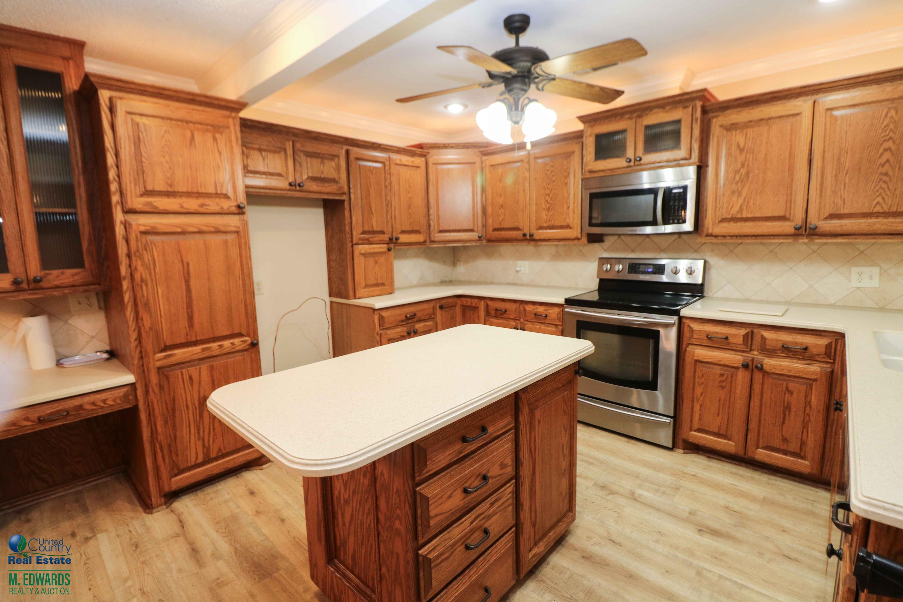 200 Crescent Drive Littlefield, TX 79339 - Photo 7 of 25 a kitchen with stainless steel appliances a stove sink microwave refrigerator and cabinets